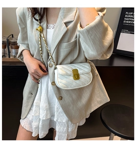 Détail du sac bandoulière blanc matelassé avec fermoir doré et chaîne élégante en métal