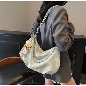 Détail du sac cabas bleu clair en cuir souple avec chaîne et charm ours en peluche