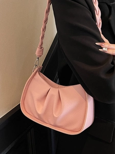 Pink pleated shoulder bag with woven strap and metallic hooks in minimalist style