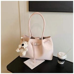 Detail of light pink tote bag with woven texture, metal buckle and cute polar bear charm