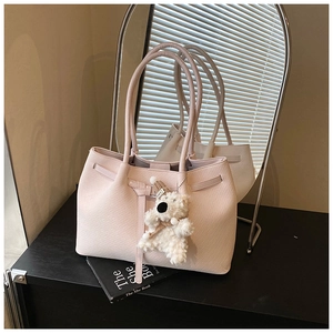 Close-up of pink tote bag showing cross-grain texture and cute plush bear charm