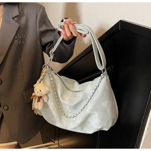 Détail du grand sac cabas bleu clair avec chaîne métallique et breloque ours blanc