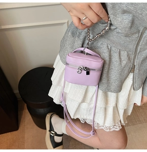 Detail of purple lychee leather mini crossbody bag with silver zipper and ball chain