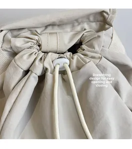 Detail of the drawstring closure on a beige nylon backpack for easy access and security