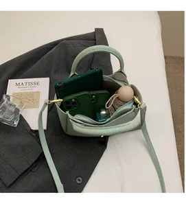 Top view of spacious interior of light green lychee texture bucket bag with daily items