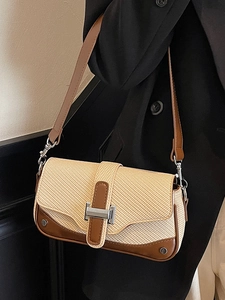 Chic retro woven shoulder bag with brown leather trim and metallic lock on a model