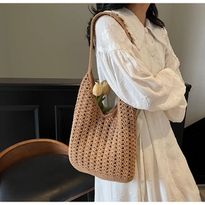 Vue détaillée du sac hobo en crochet marron assorti à une robe en dentelle blanche