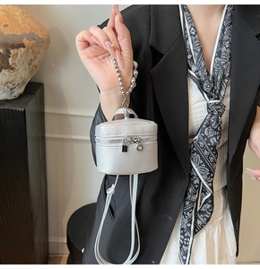 Detail of silver mini crossbody bag with litchi texture and elegant beaded handle