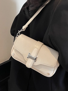 Chic two-tone shoulder bag with metal H-buckle worn over a black blazer for women