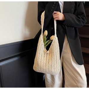 Détail d'un sac cabas beige au crochet montrant des motifs tissés et tulipes jaunes