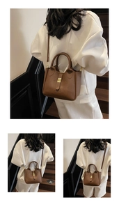 Close-up of deep brown lychee texture leather bucket bag with golden twist lock detail