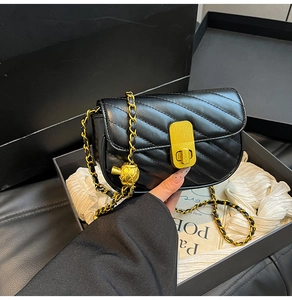 Détail du sac bandoulière en cuir noir matelassé avec chaîne dorée et boucle à bille coulissante