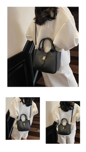 Detail showing the textured black lychee grain leather and golden buckle of the handbag