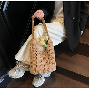 Gros plan du sac fourre-tout tissé camel montrant la texture géométrique évidée