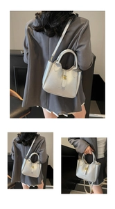 Detail of silver lychee texture bag with gold hardware buckle and brand logo