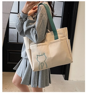 Detail view of large canvas tote bag showing side pocket and minimalist cat design
