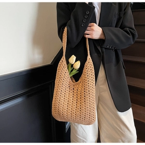 Gros plan d'un sac hobo en crochet tissé à la main kaki clair avec accents floraux