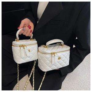 Detail showing two sizes of white quilted leather chain bags with gold flower logo
