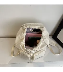 Top view of cream white backpack interior showing large capacity for tablet and wallet