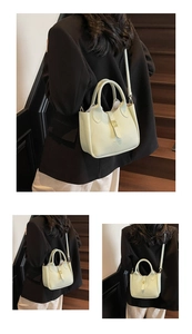 Detail showing the mint green leather bucket bag with golden twist lock and adjustable strap