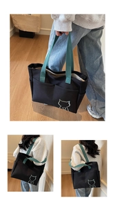 Detailed view of black canvas tote bag with tiffany blue handles and cat embroidery