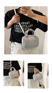 Detail of light blue mini retro crossbody bag with embossed lettering and silver hardware