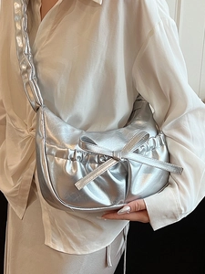 Silver metallic pleated underarm bag with bow decoration and stylish crescent shape