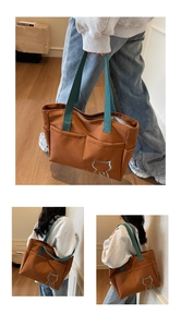 Detail view of large brown canvas tote bag with cat embroidery and blue shoulder straps
