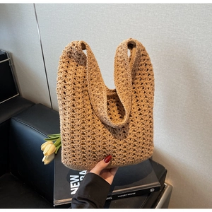Détail d'un sac cabas en paille tissé main avec texture dense et large bandoulière