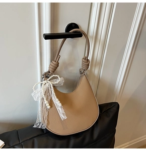 Dettaglio borsa a mezzaluna kaki con pelle martellata e tracolla a nodi