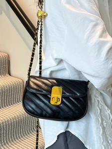 Sac bandoulière élégant en cuir matelassé noir avec chaîne dorée portée par mannequin