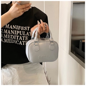 Detail of light blue leather handbag featuring 3D embossed RETRO text and silver zipper