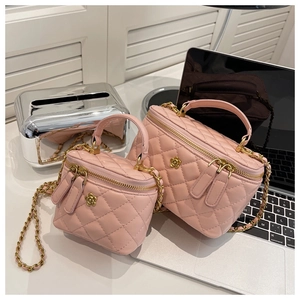 Detailed view of pink quilted leather box bags with golden flower buckles and chain straps
