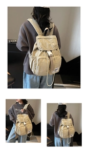 Detail view of beige nylon backpack featuring flap pocket and drawstring side pouches