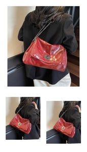 Detail of red glossy PU leather tote bag with silver chain strap and metal swivel lock