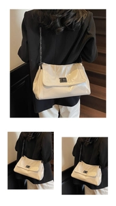 Detail of cream patent leather tote with silver chain strap and metal lock closure