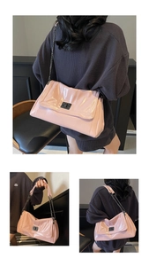 Close-up of pink patent leather tote bag with black metal chain and turn-lock closure