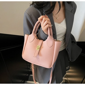 Pink lychee grain leather bucket bag with gold twist lock and logo detail on stairs