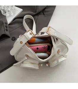Detail view of white punk style crossbody bag with multiple pockets and interior storage