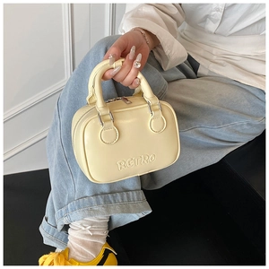 Detailed macro view of smooth yellow PU leather handbag featuring RETRO embossed text