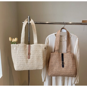 Détail de sacs cabas en paille tissée à la main beige et kaki avec texture fine et lanières cuir