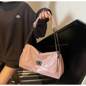 Detail of soft pink glossy tote with retro metal twist lock and dual chain shoulder strap