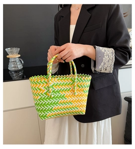 Détail d'un panier tressé coloré avec motif à chevrons vert et jaune sur la anse