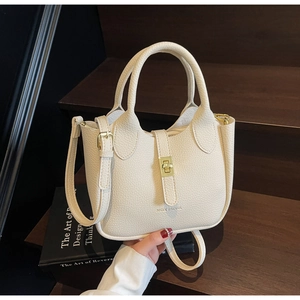 Detail of lychee textured leather bucket bag with gold hardware and top handle