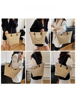 Detail of minimalist straw tote bag featuring contrast handles and printed TOTE BAG text