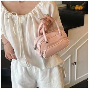 Detail of pink lychee pattern leather Boston bag with silver hardware and double handles