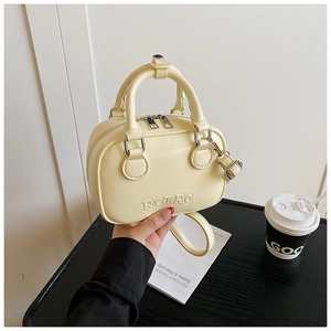Detail of cream yellow leather handbag with embossed RETRO letters and dual zippers