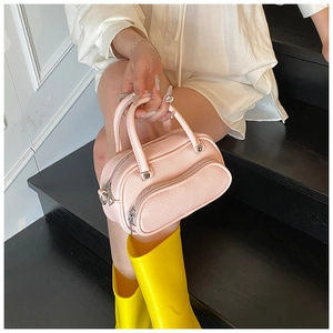 Top view of pink lychee leather mini pillow bag with front zipper and top handle detail