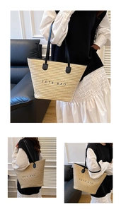 Detailed close-up of straw woven tote bag with black TOTE BAG text and leather straps