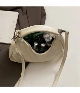 Detailed interior of minimalist cream leather handbag showing ample storage space